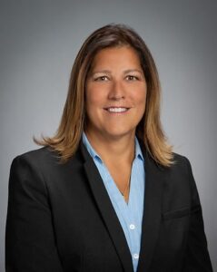 Lisa Asper headshot in a black jacket and blue button down